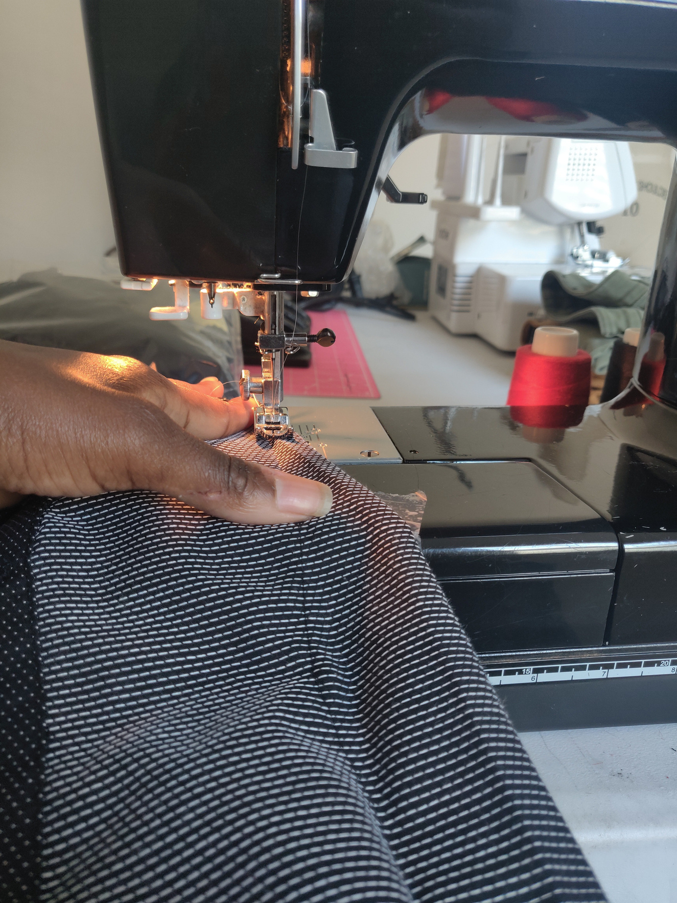 a person is sewing a piece of fabric on a sewing machine