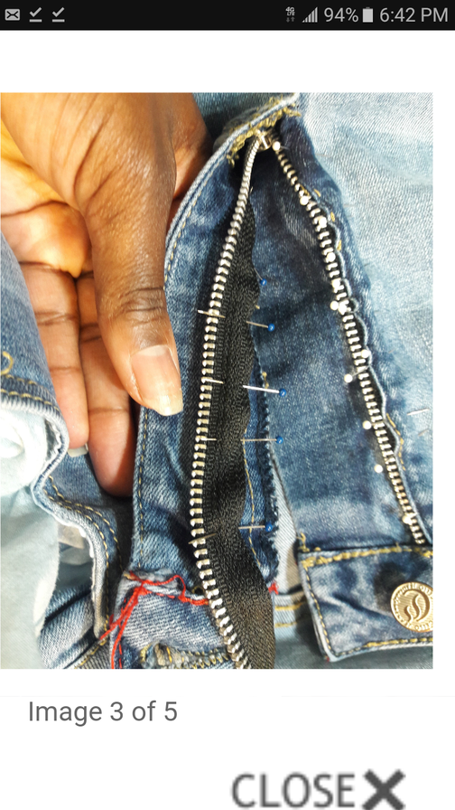 a person holding a pair of jeans with a zipper