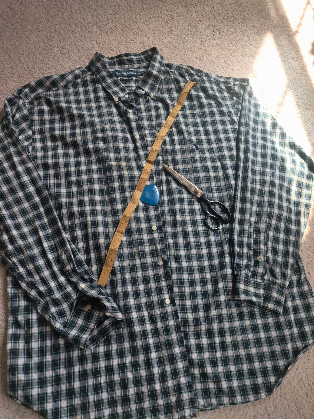 a shirt with a pair of scissors sitting on top of it