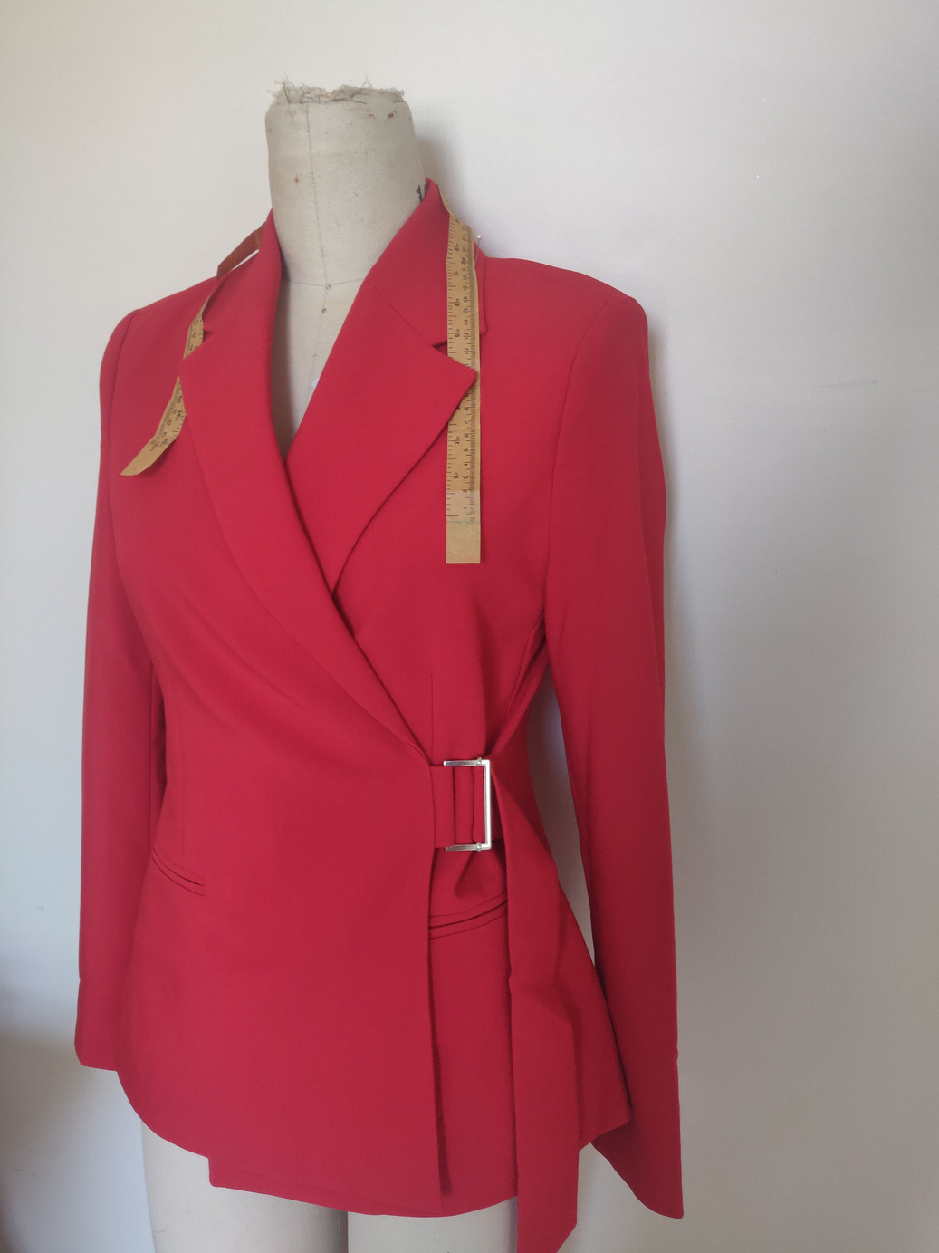 a red blazer with a belt around the waist