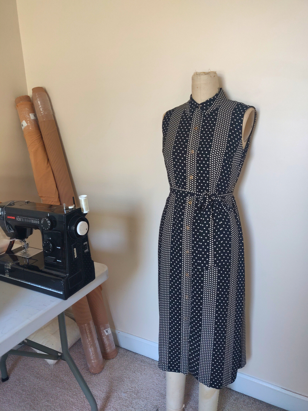 a dress on a mannequin in front of a sewing machine