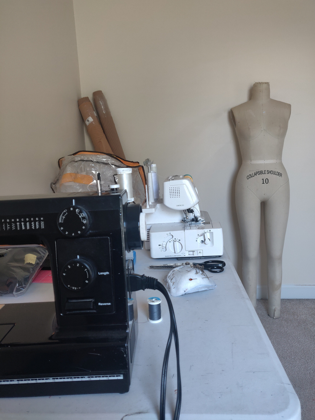 a sewing machine on a table next to a mannequin